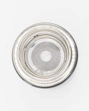 An Infuser Basket for Stainless Steel Bottles with a lid on a white surface by Cognitive Surplus.