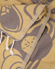 A Tide Pool Turkish Towel with tassels on it.
